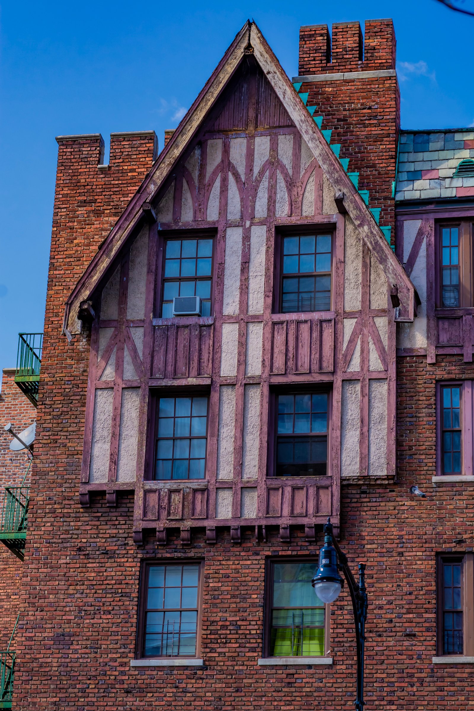 A half-timbered gable and brick chimneys at the Allerton Coops, photographed in 2018.