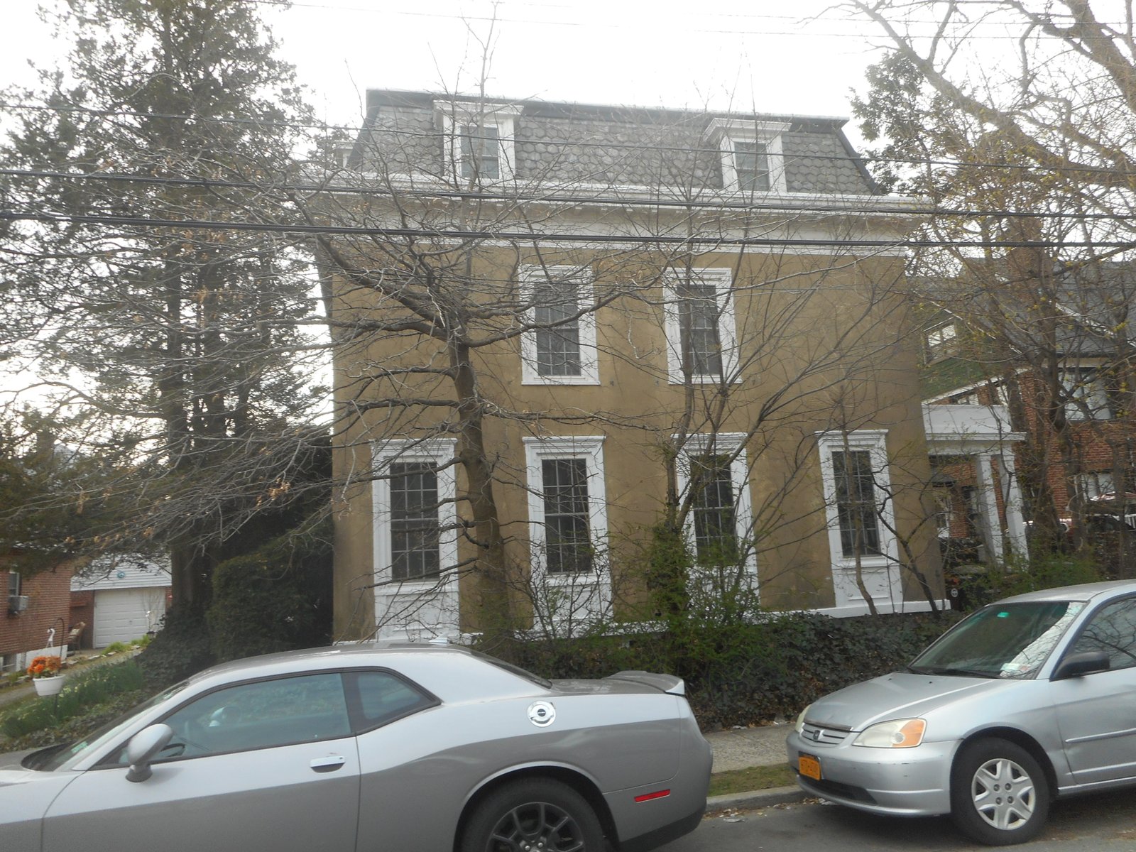 The Bell-Ahles House with a mansard roof, dormers and pale stucco walls.