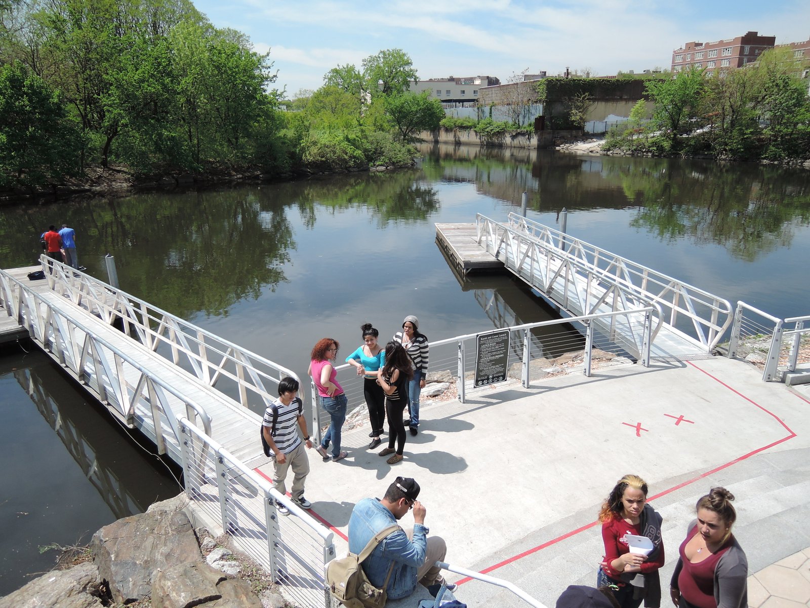 The boat dock and Bronx River at Starlight Park, with visitors on the launch approach, photographed in 2013.