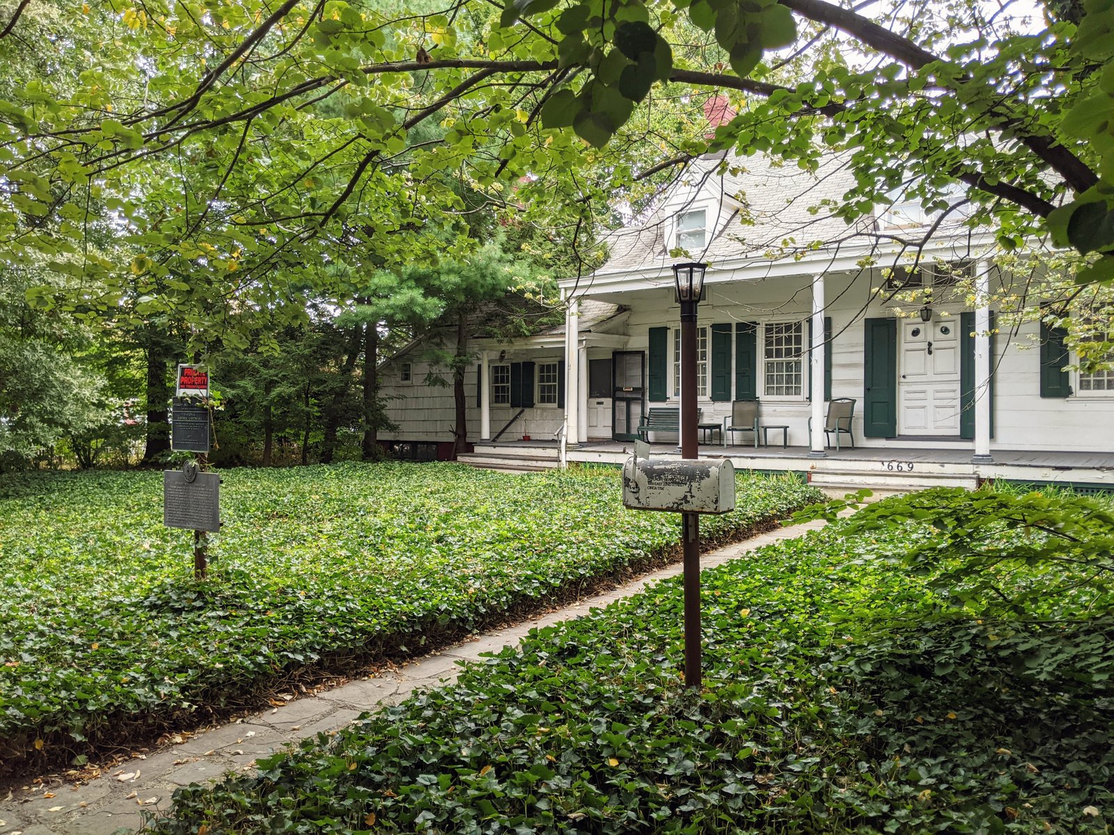 Wyckoff-Bennett Homestead with its long porch and green shutters, photographed in 2021.