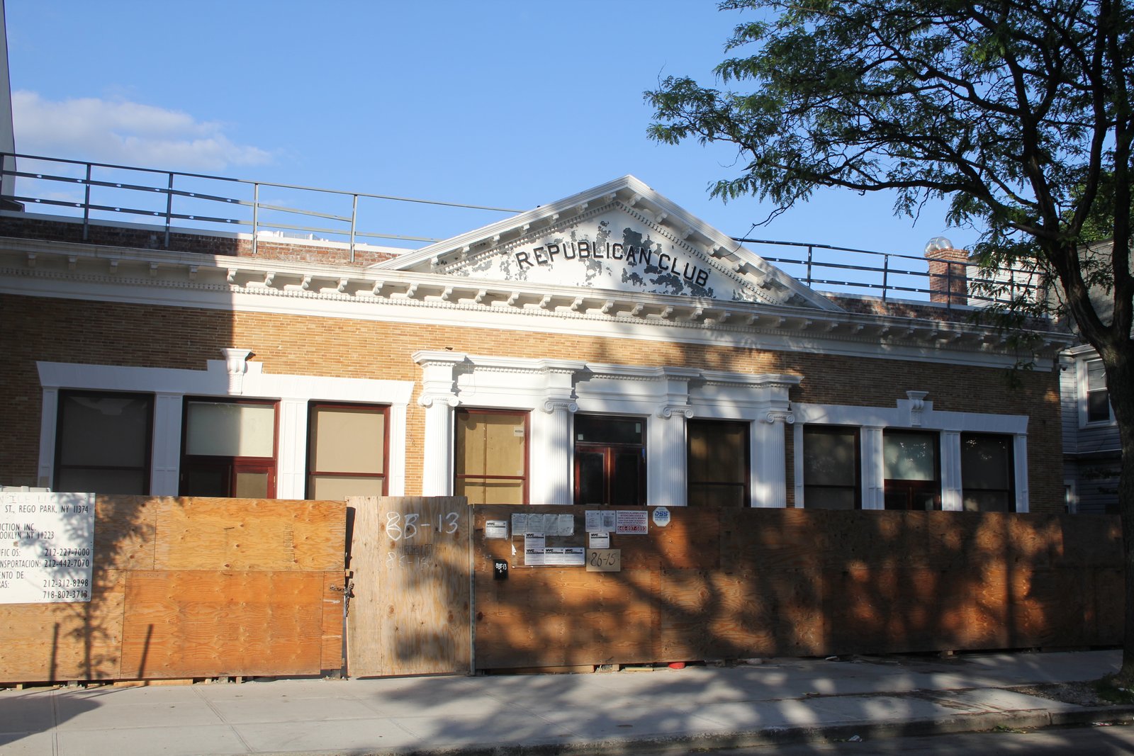 Richmond Hill Republican Club brick facade and lettered pediment above temporary plywood hoarding, June 2014.