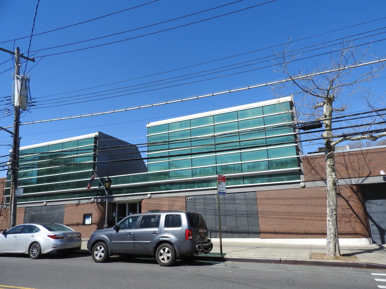 New Dorp Library on New Dorp Lane in 2018, showing its brick street level and broad green glass facade.