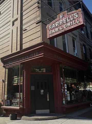 The corner entrance and red sign of Farrell’s Bar & Grill.
