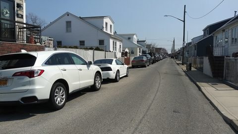 Houses and parked cars along a Gerritsen Beach street.