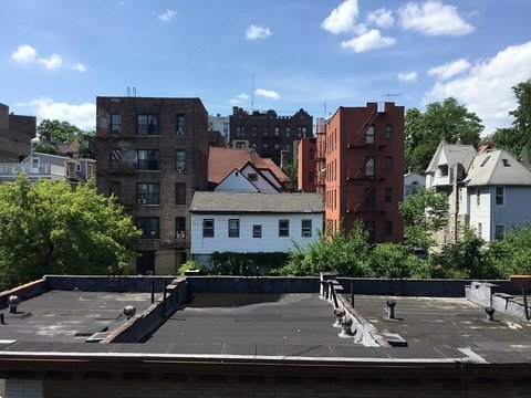Houses and trees seen from the elevated Marble Hill–225th Street station.