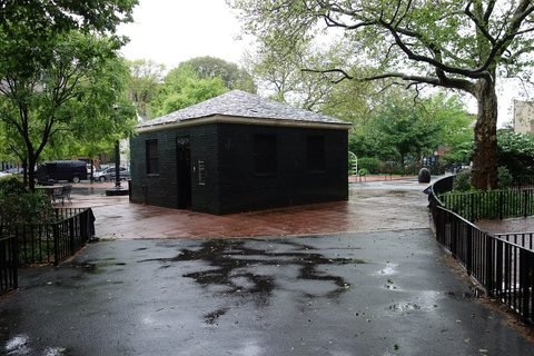 A path and park building under trees at Winthrop Playground.