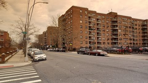 Apartment buildings and parked cars along Avenue Y.