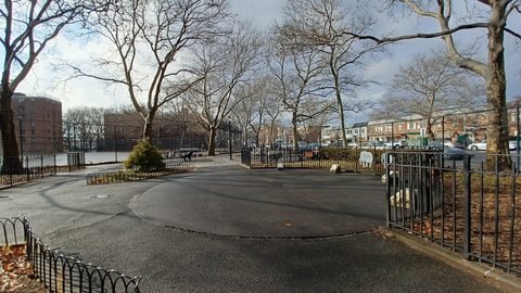 Paths and trees in Herman Dolgon Playground with housing in the background.