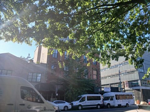 The former 32nd Precinct Station on Amsterdam Avenue, partly screened by a street tree.