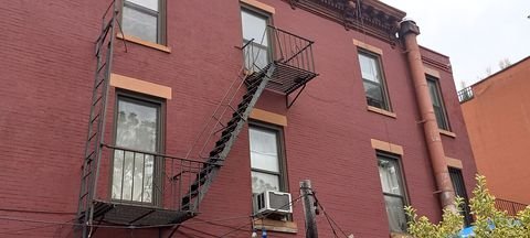 Brick house fronts with a metal fire escape in Carroll Gardens.