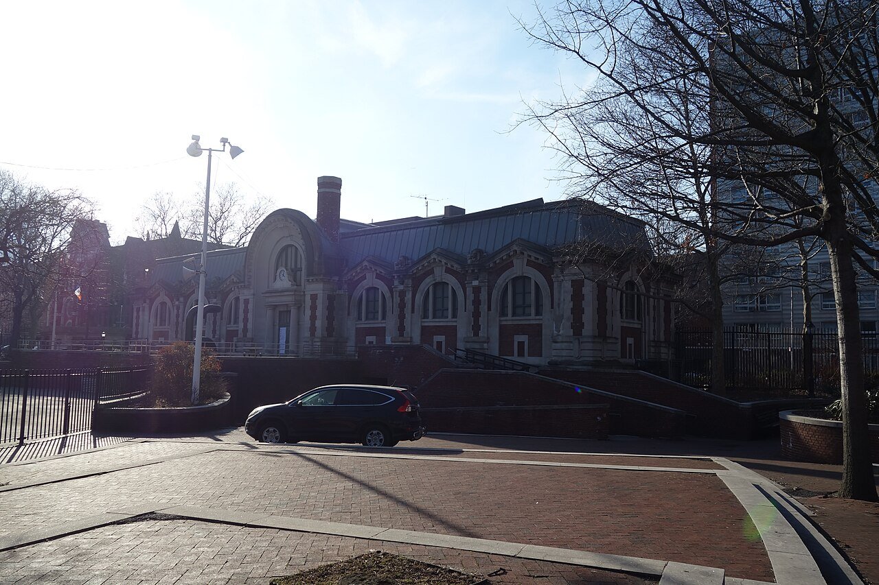 Hamilton Fish Park Play Center's central arch and arched window bays, seen from the park in 2019