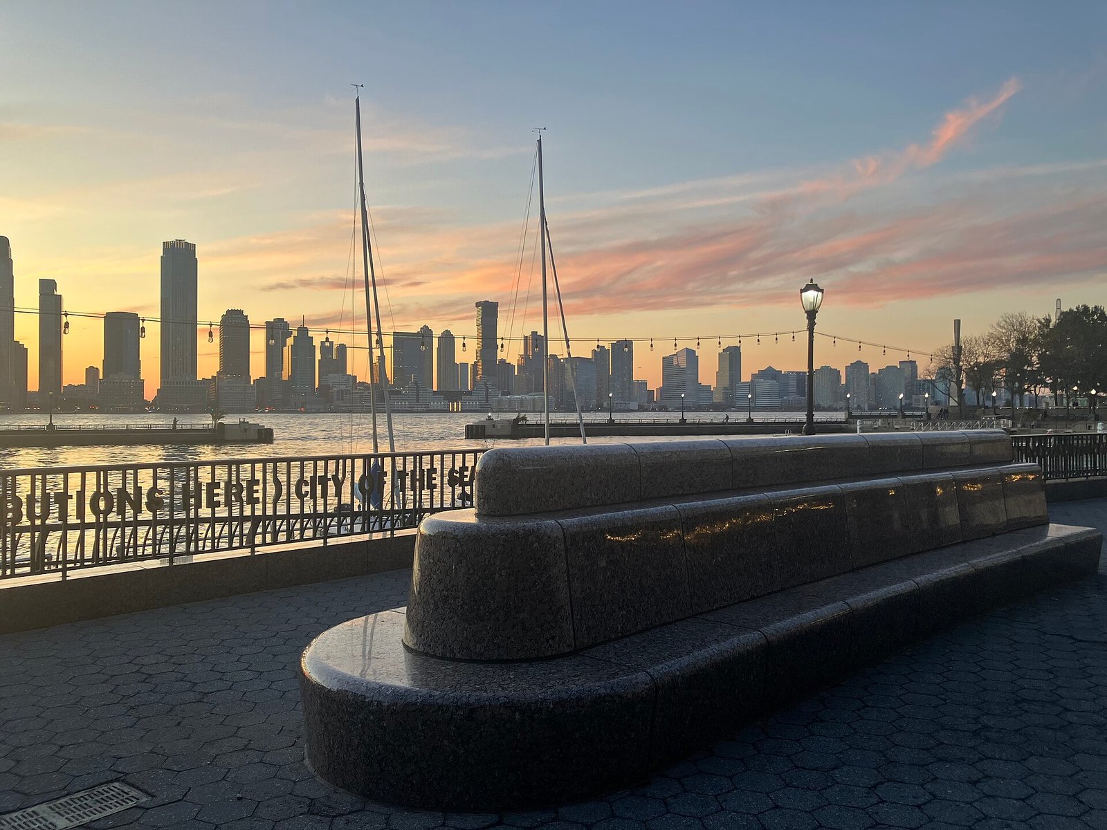 Benches and a railing overlook the Hudson River and the Jersey City skyline at North Cove.