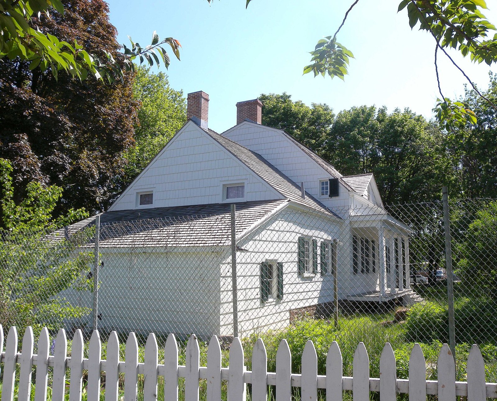 The historic white Lott House behind fencing, seen from the street in 2009.