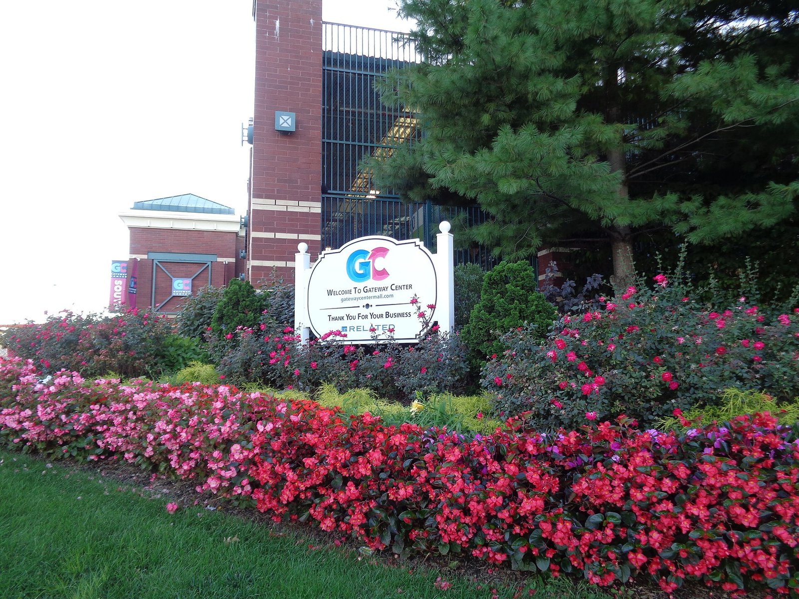 Flowers surround a Gateway Center welcome sign by Erskine Street.